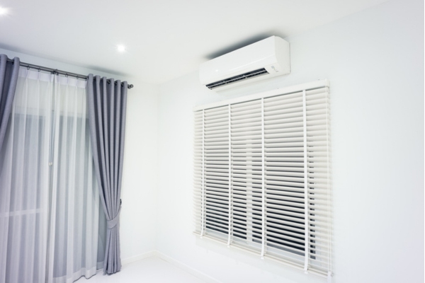 ductless air conditioner on top of venetian blinds at home