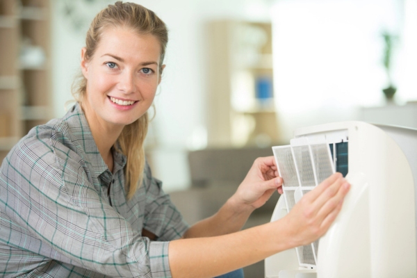 woman checking portable air conditioner filter