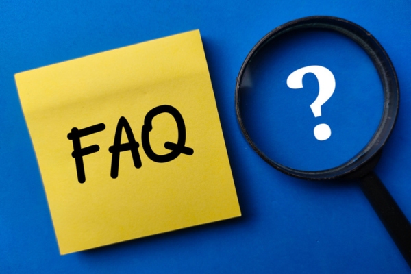 FAQ written on yellow sticky note with magnifying glass on the side showing question mark