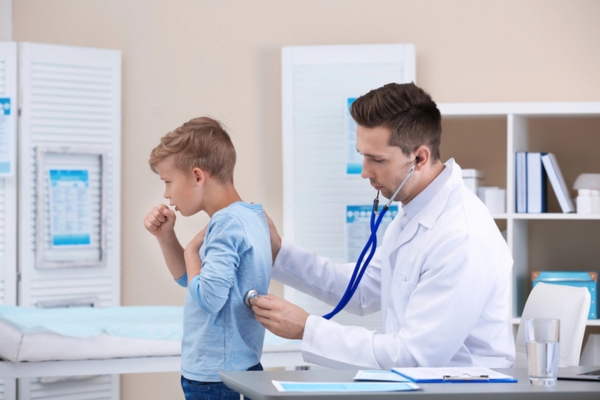 coughing boy getting checked by a doctor depicting Symptoms of AC sickness