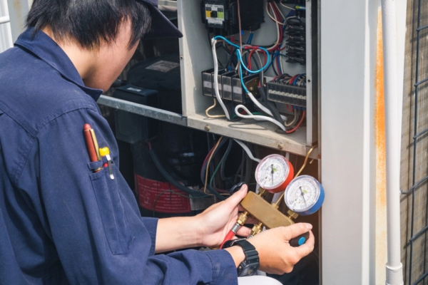 HVAC technician servicing air conditioner unit