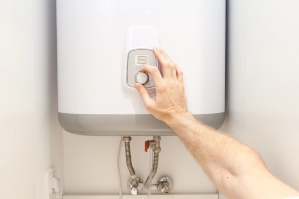 Close-up of man hands setting the temperature of water heater