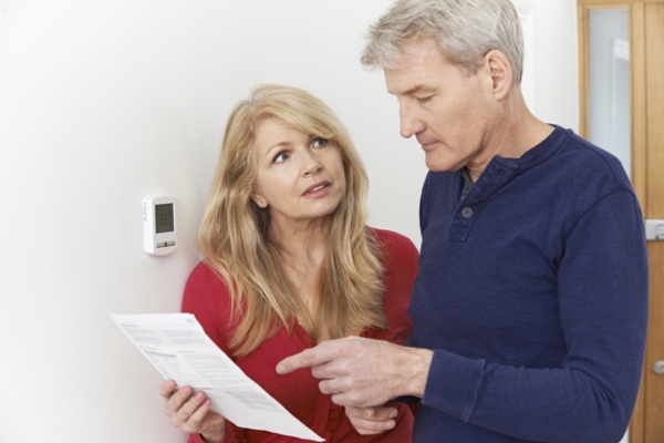 couple looking at energy bill depicting ways to reduce heating bills