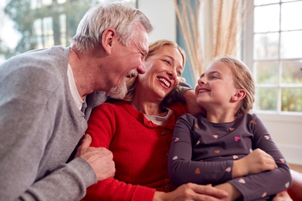 Grandparents and granddaughter all wearing sweaters while sitting on couch depicting personalized comfort & efficiency