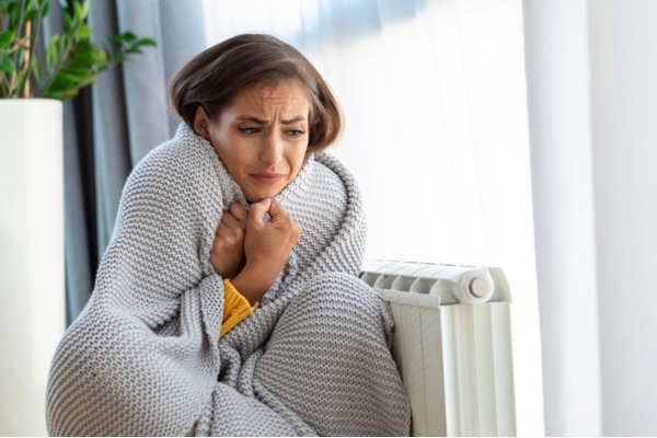 woman feeling cold indoors due to frozen heating oil