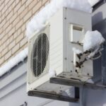 image of a heat pump in winter after a snowfall