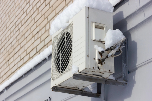 image of a heat pump in winter after a snowfall