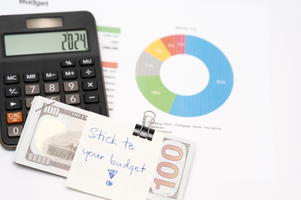 stick to your budget note clipped on dollar bills and calculator with budget charts depicting purchasing a new furnace