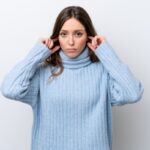 woman covering her ears due to rattling furnace