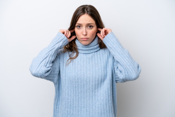 woman covering her ears due to rattling furnace