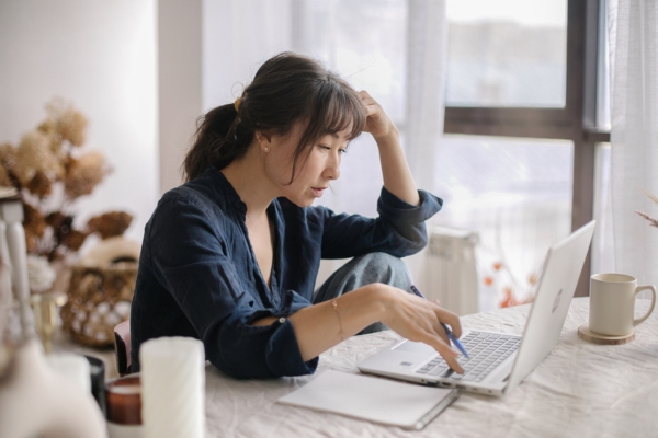 woman looking at computer comparing will call vs automatic oil delivery