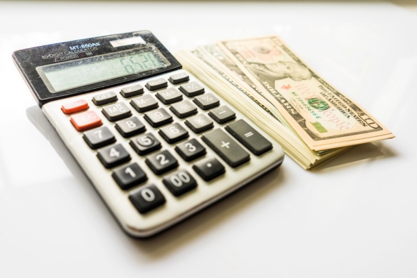 image of a stack of cash and calculator depicting planning ahead for fuel oil prices